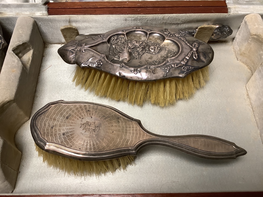 A cased George V silver four piece mirror and brush set, Birmingham, 1912, together with one other brush and a shoe horn.